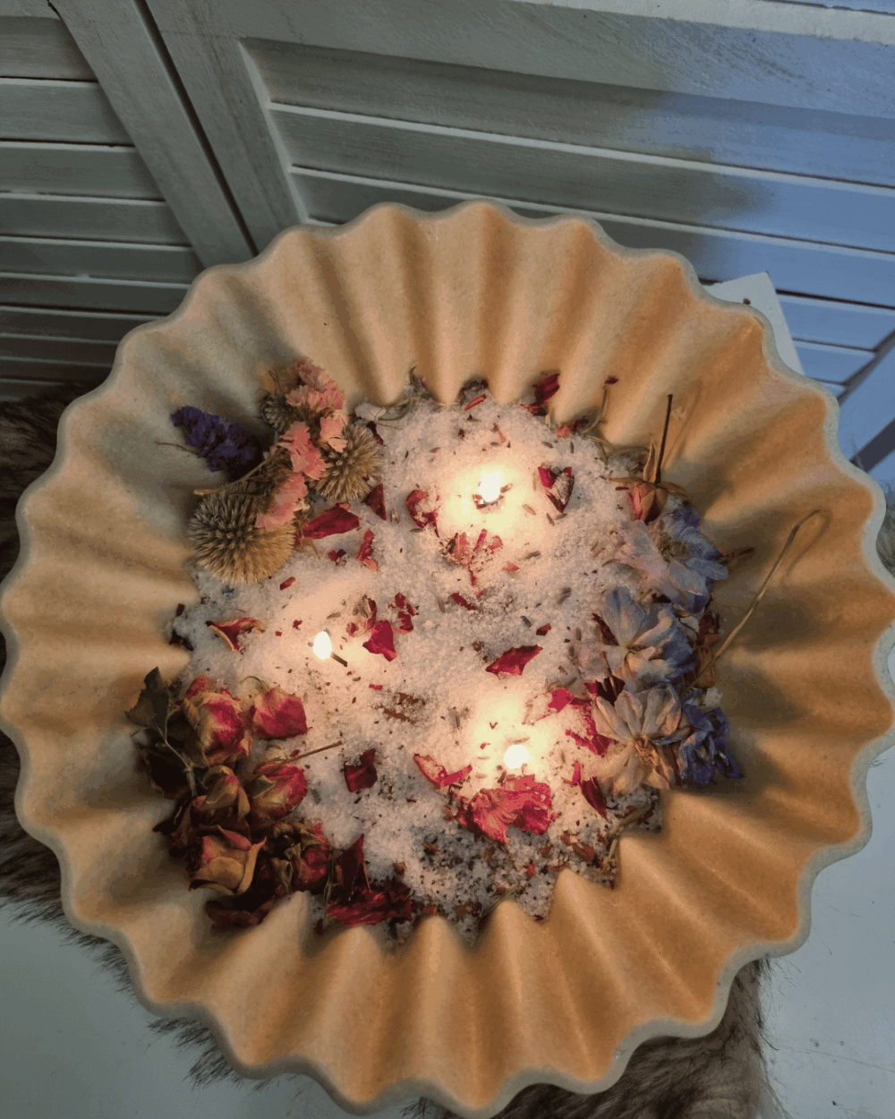 Schaal met geurend kaarsenzand en droogbloemen